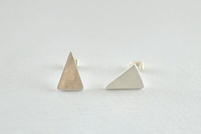 Ασημένια ματ καρφωτά σκουλαρίκια τριγωνάκια διαστάσεων 1,4 x 1 εκ. Τα τριγωνάκια έχουν αντίθετη φορά μεταξύ τους.